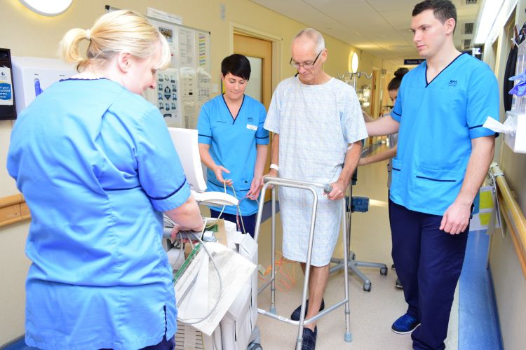 nurses with patient using walking frame