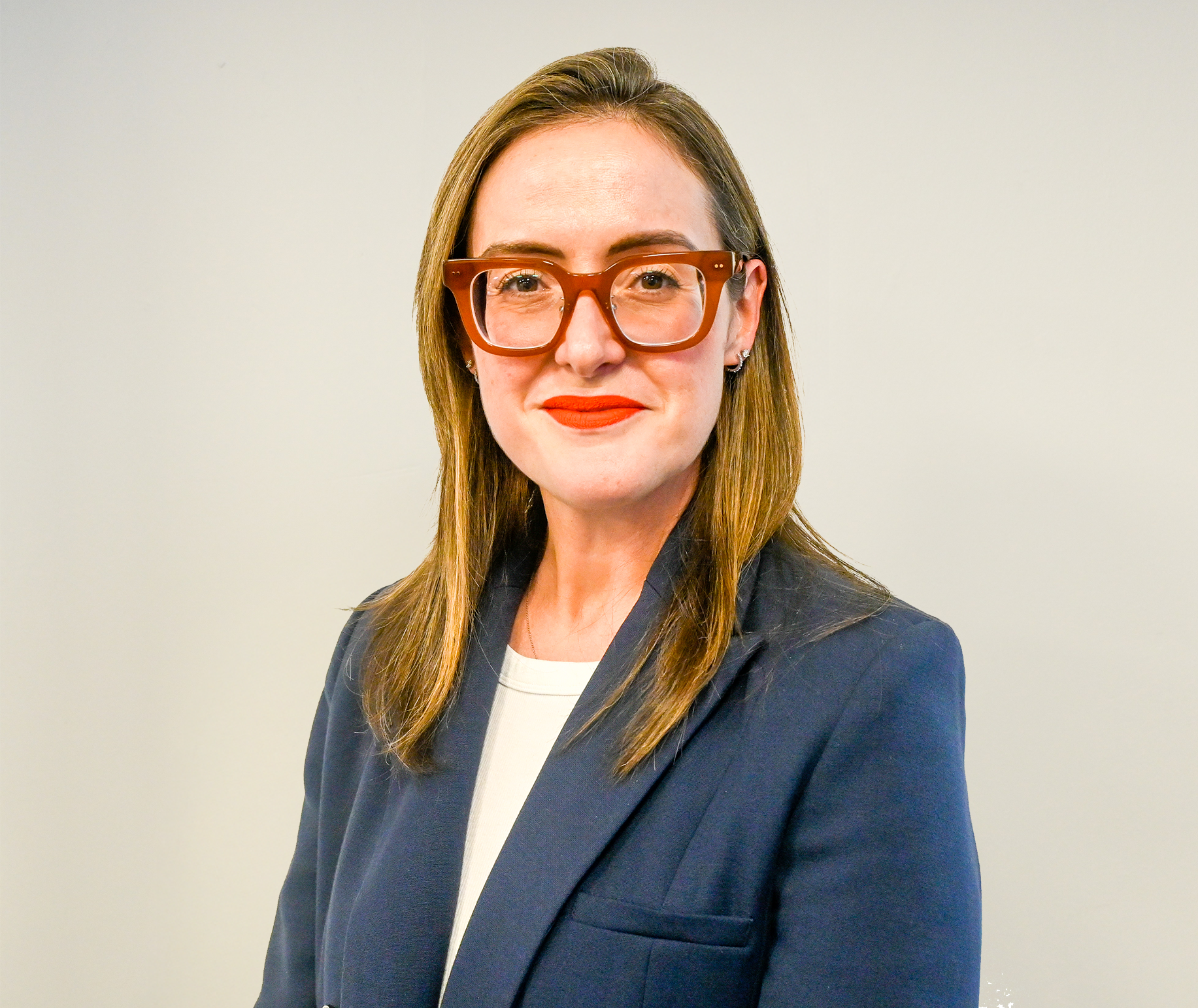 Laura smiling and wearing white shirt with red lipstick.