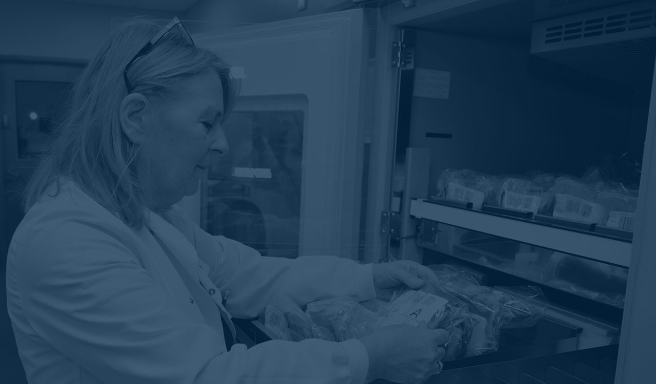 Woman in lab coat looking through files. 