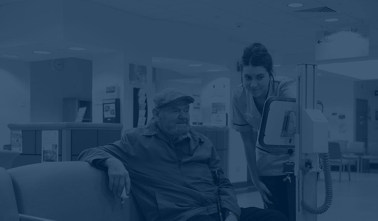 Female nurse showing elderly man information on a screen.