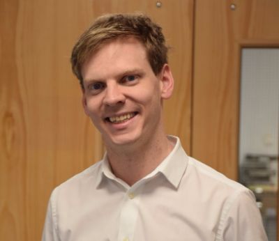 Gordon Adamson, Pharmacist, standing smiling.