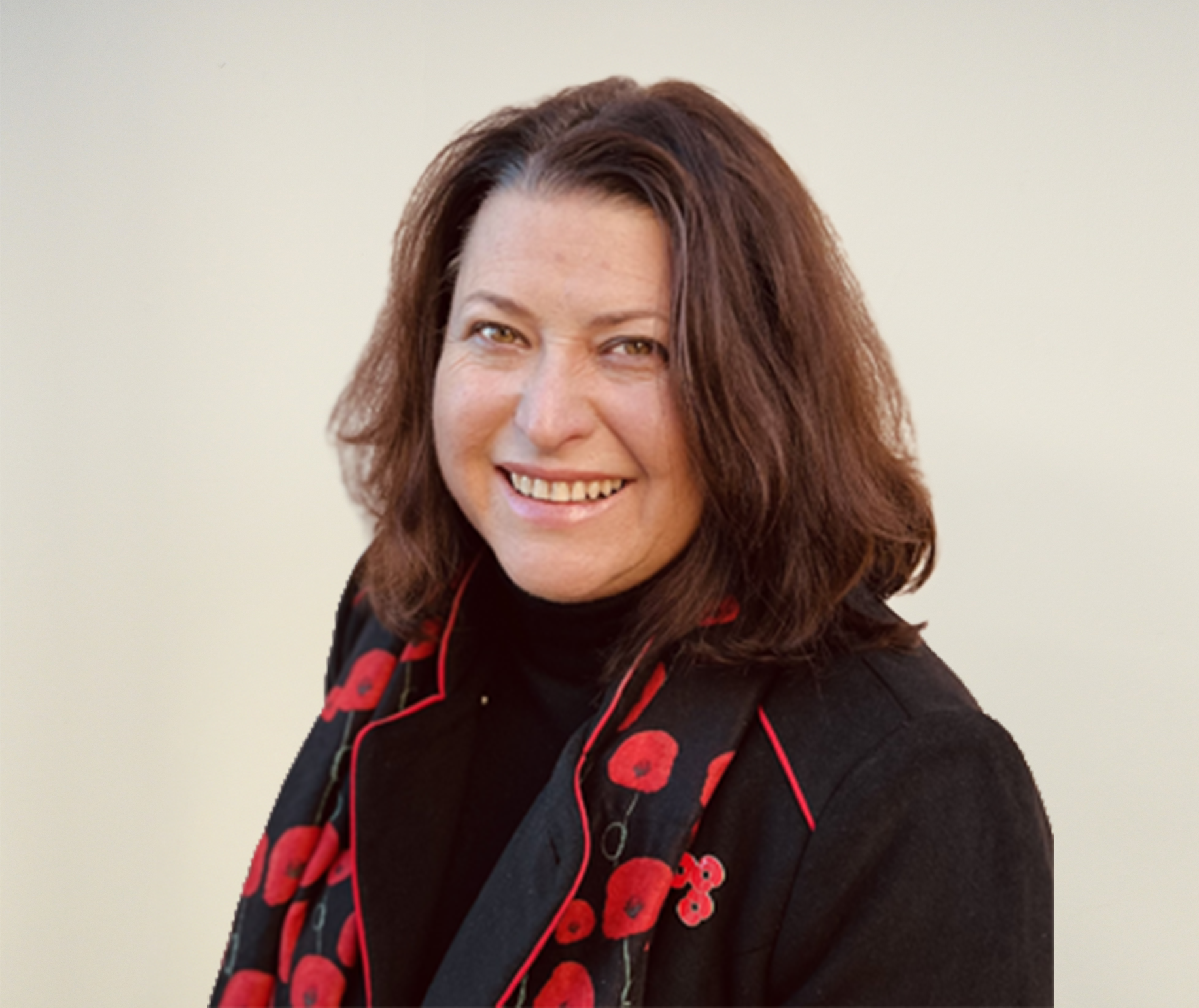 Sandie smiling whilst wearing poppy scarf and poppy.