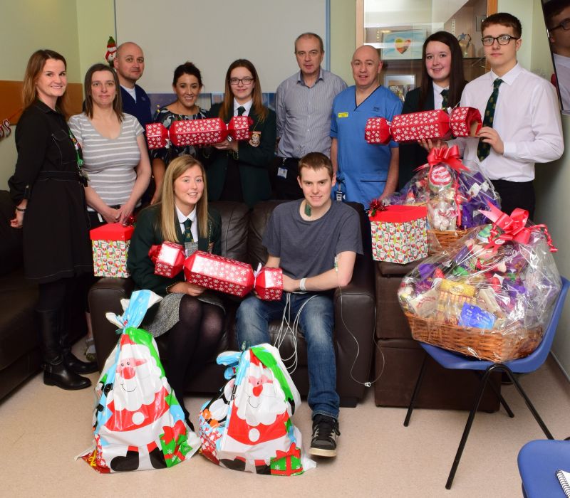 Anna Hemphill (front left, sitting) with patient Euan Bisset, school friends, teacher Colette Watt (left) and Golden Jubilee National Services Division (NSD) staff with all the presents